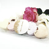 A packet of five heart shaped bath bombs with flowers behind