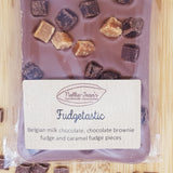 A close up of a slab of handmade Belgian milk chocolate with fudge pieces, showing the label