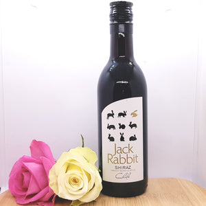A bottle of Jack Rabbit Shiraz decorated with two flowers