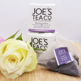 A bag of earl grey tea, two boxes of earl grey tea, decorated with a flower