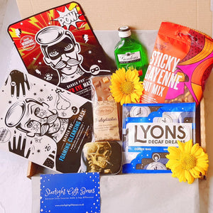The contents of the mens pamper gift box, showing two face masks, a miniature bottle of gin, a nut mix, a coffee bag, a belgian chocolate slab and a tin of mints