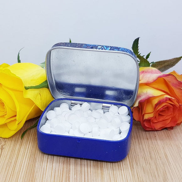 An open tin of mini mints, decorated with two flowers